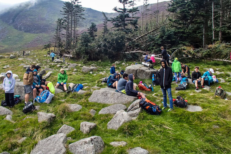 Eine große Gruppe von Schüler:innen legt eine gemeinsame Wanderpause ein beim Sprachaufenthalt Schottland