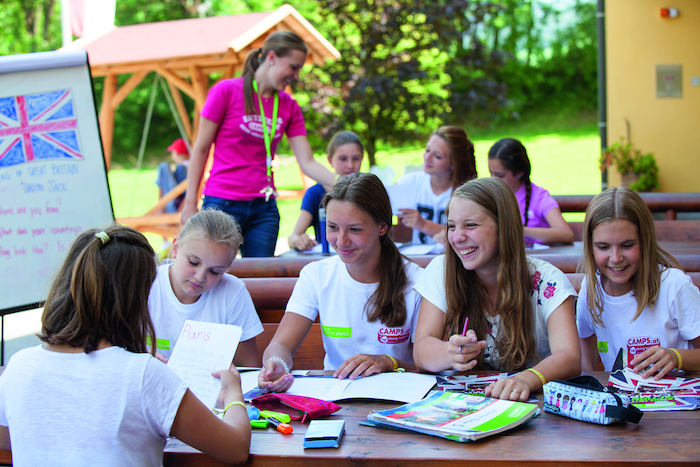 Mädchen lernen gemeinsam am Tisch Englisch mit Büchern und Heften 
