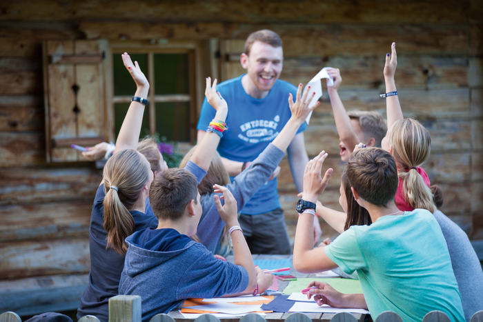 Mehrere Teilnehmer eines Englischcamps Schweiz melden sich im Sprachunterricht der draussen stattfindet