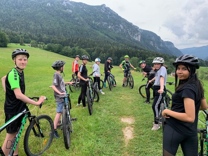 Eine Gruppe Kinder und Jugendliche machen eine Fahrradtour im Feriencamp Basel