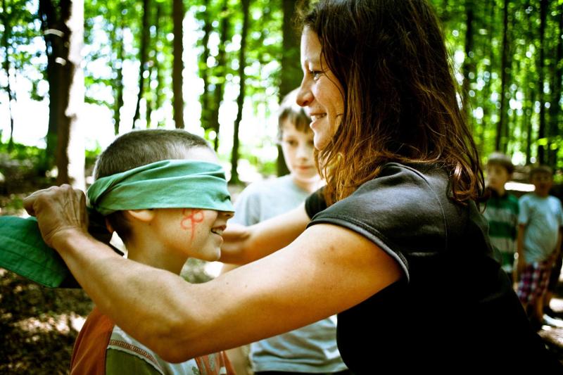 Erlebt gemeinsam neues bei eurem Familienurlaub Eine Mutter verbindet ihrem Kind die Augen bei einer Erlebniswanderung zum schärfen der Sinne