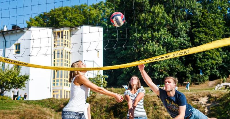 Mehrere Kinder spielen Beachvolleyball bei den bei den Aktiv-Camps