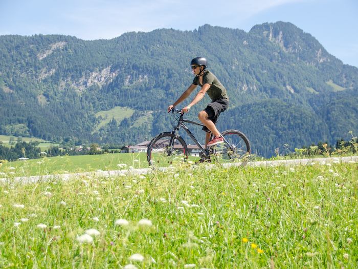 Im Englischcamp Österreich fährt ein Teilnehmer auf dem Fahrrad vor einem Berg