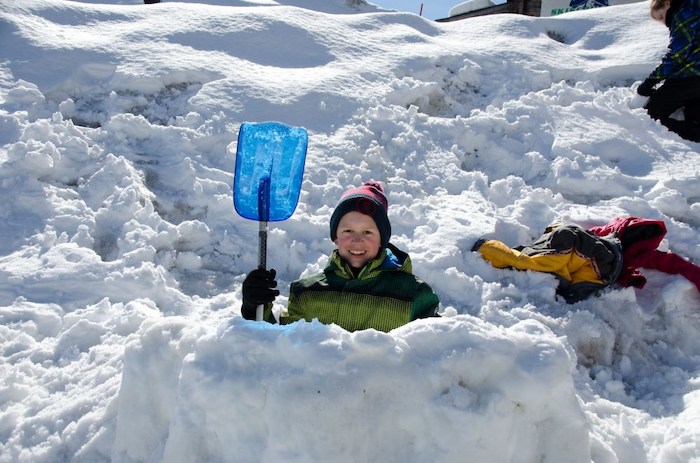 Ein Kind baut ein Iglu im Ferienlager Freiburg