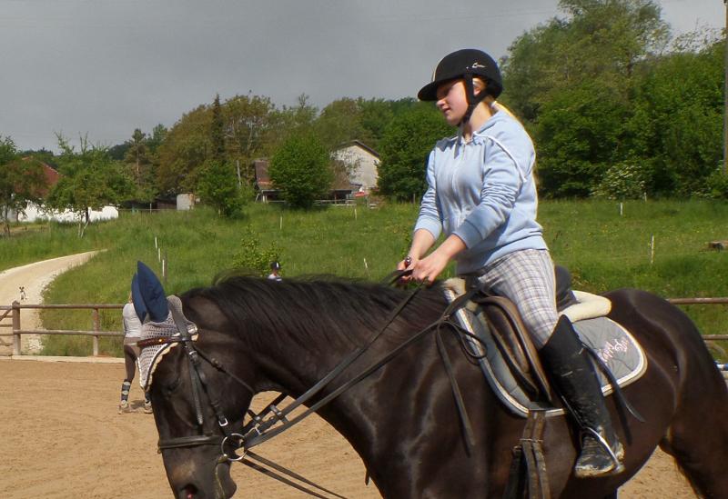 Mädchen reitet auf einem Pferd währen einem Reitlager Kinder