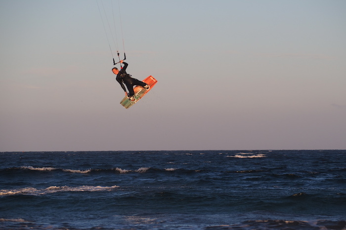 Person macht Sprung in der Luft im Surfcamp