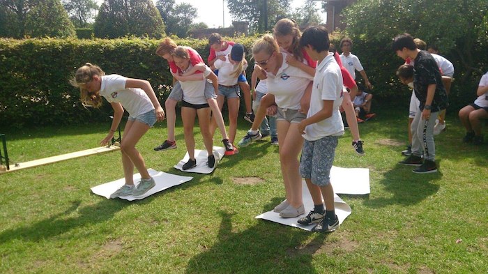 Die Teilnehmer des Juvigo Actioncamps spielen ein Spiel bei dem sie sich gegenseitig tragen und nicht auf den Boden stehen