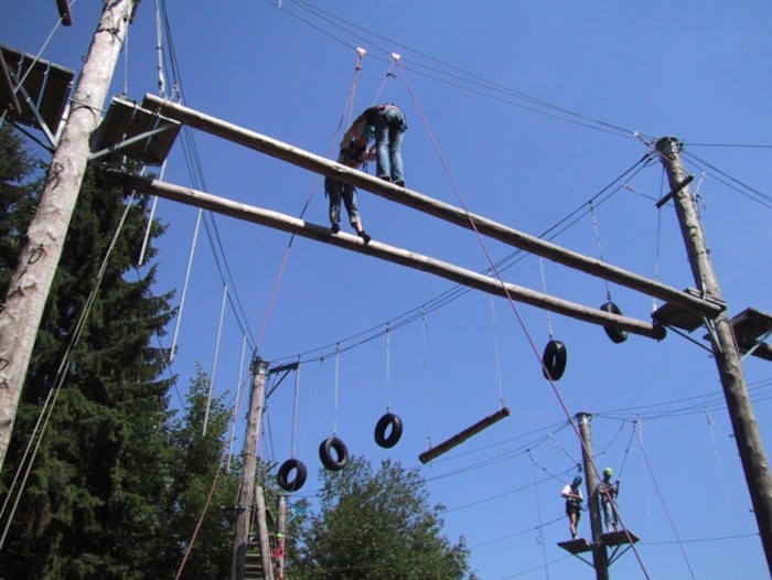 Kinder klettern in einem Hochseilgarten im Abenteuerurlaub