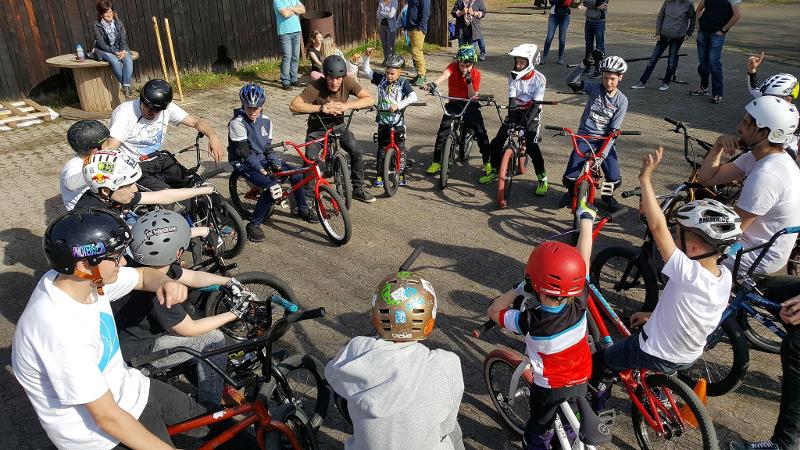 Eine Gruppe von Kindern steht mit ihren BMX Rädern im Kreis