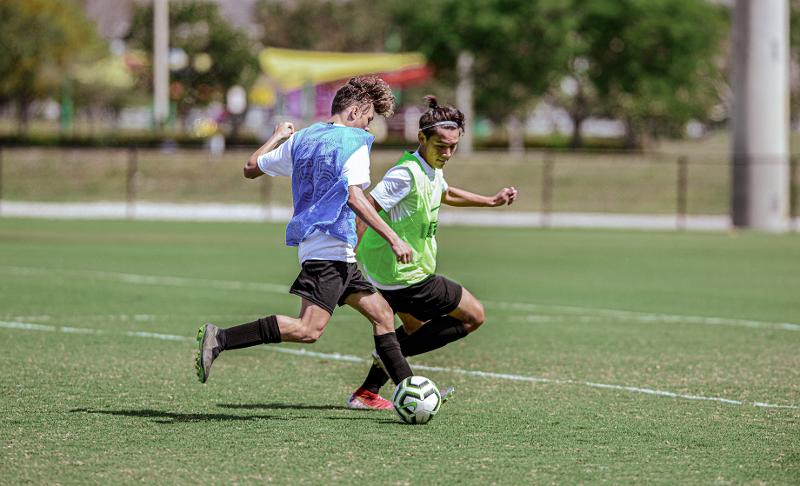 Jungs spielen Fussball gegeneinander im Zweikampf 