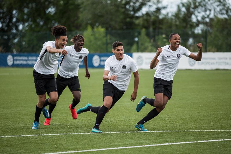 Vier Jungen in Trikots jubeln beim Fußball spielen während ihrer Frankreich Sprachferien