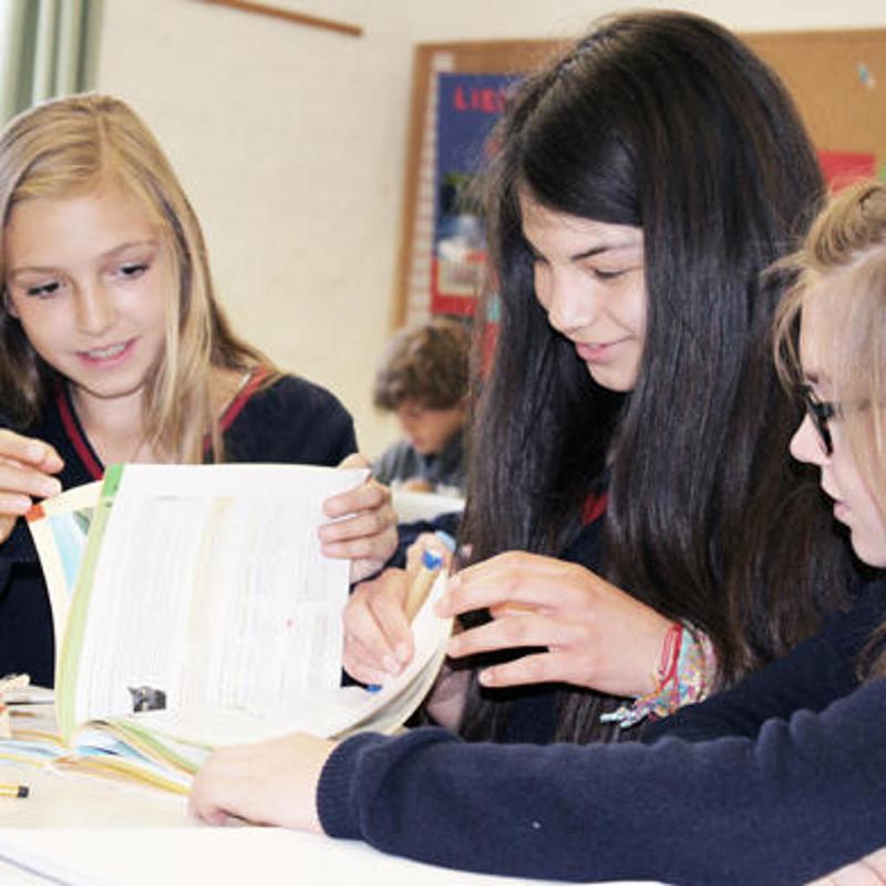 Mädchen lesen Bücher im Unterricht während eines Englisch-Camps