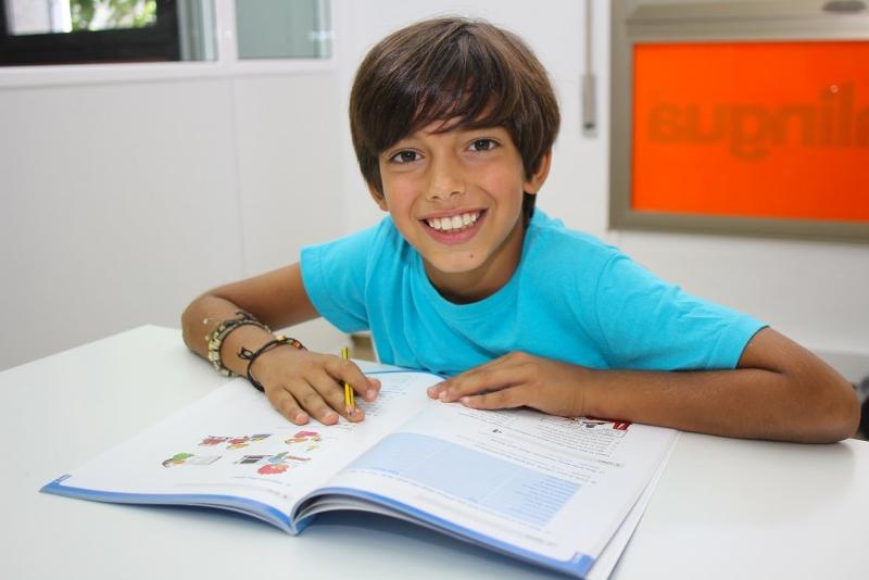 Teilnehmer eines Sprachcamps hält einen Stift in der Hand und liest ein Lehrbuch