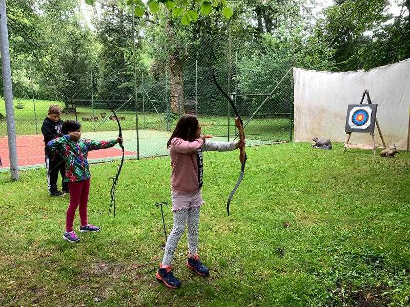 Drei Kinder üben das Bogenschiessen auf der Sprachreise