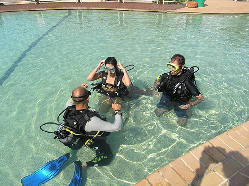 Kinder der Jugendreise Tauchen üben im Pool bevor sie in der freien Wildbahn tauchen