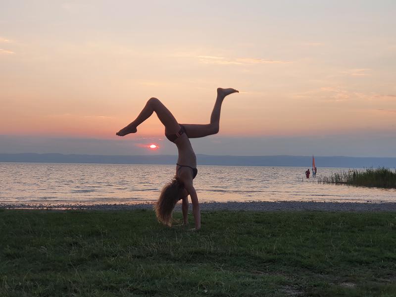 Mädchen macht Handstand auf Wiese im Ferienlager Deutschland