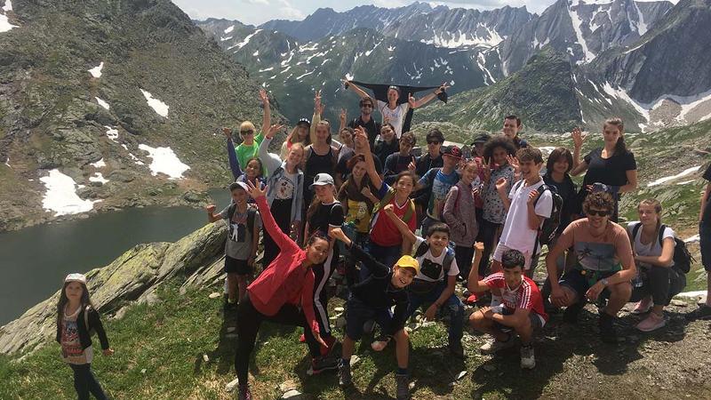 Gruppenfoto von den Teilnehmern eines Mathe-Feriencamps stehen auf einem Berg mit Aussicht auf einen See