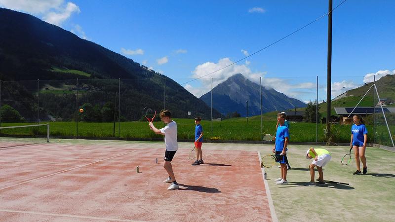 Jugendliche üben Schlagtechniken beim Tennis auf einer Sprachreise Schweiz