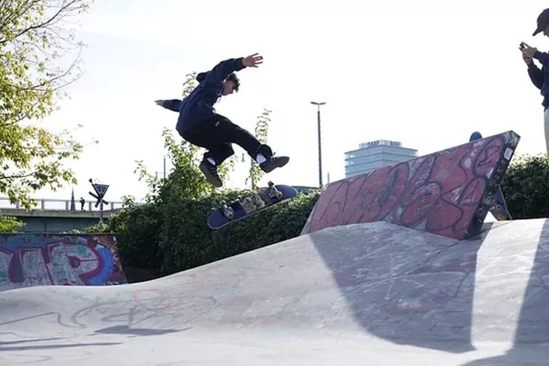 Ein Junge des Skatecamps macht einen Kickflip