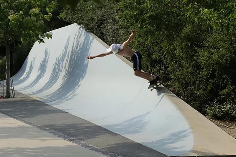 Junge übt Tricks mit dem Skateboard an einer Rampe