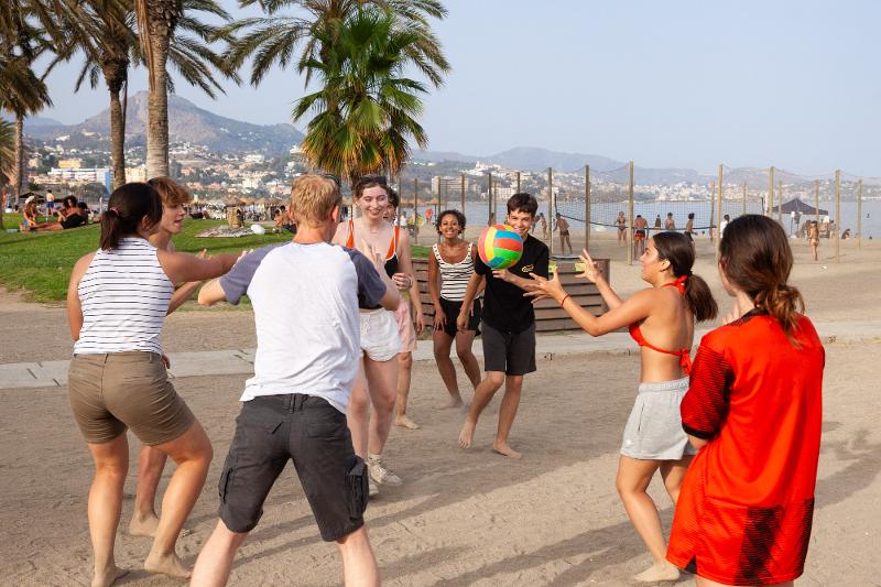 Jugendliche spielen mit einem Ball am Strand