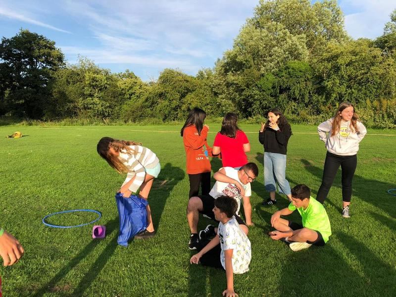 Eine Gruppe Kinder und Jugendlicher spielen gemeinsam im Grünen