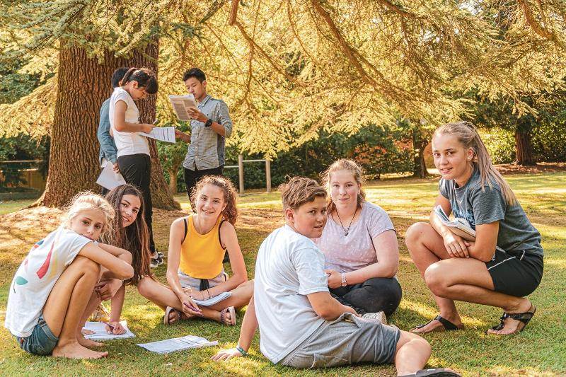 Mehrere Kinder lernen gemeinsam im Park auf einer Wiese während ihrer Schülersprachreise Schottland
