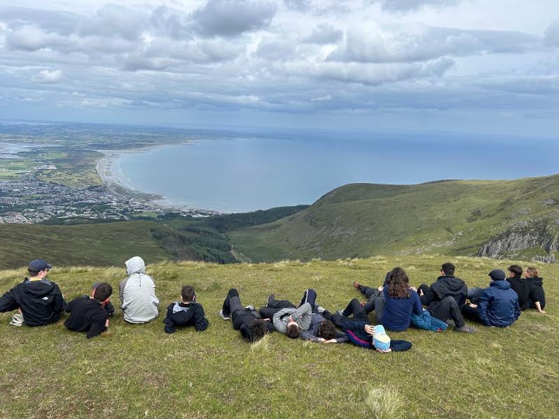 Teilnehmende, die auf einem Berg in die Ferne schauen.